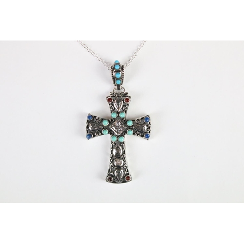 295 - A silver pendant cross set with turquoise and ruby cabochons.