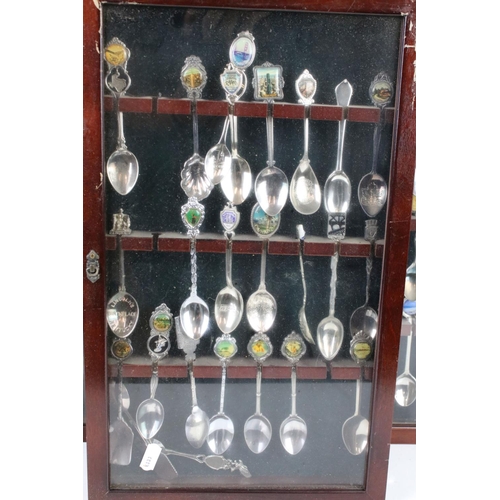 317 - A large collection of souvenir spoons contained within three collectors cabinets.
