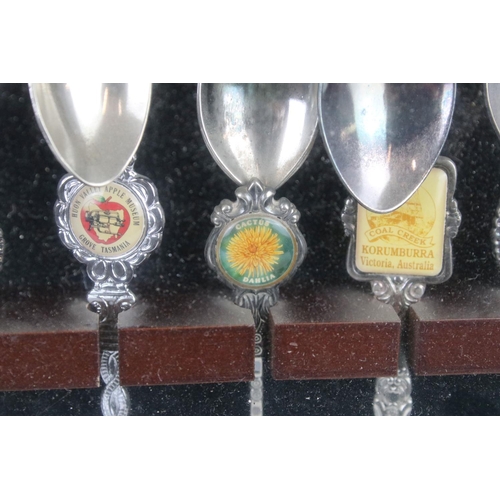 317 - A large collection of souvenir spoons contained within three collectors cabinets.