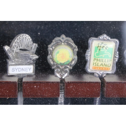 317 - A large collection of souvenir spoons contained within three collectors cabinets.
