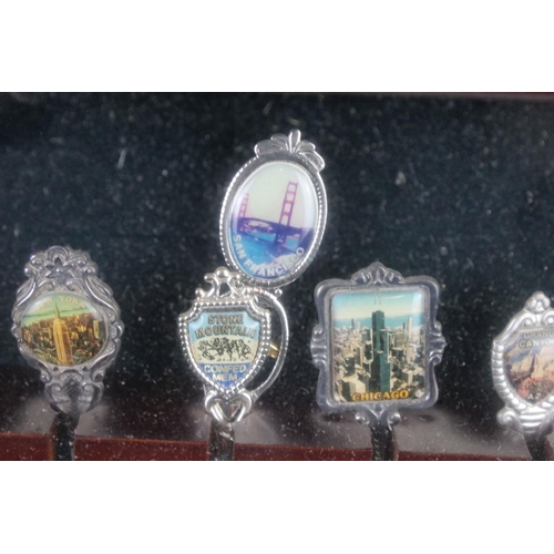 317 - A large collection of souvenir spoons contained within three collectors cabinets.