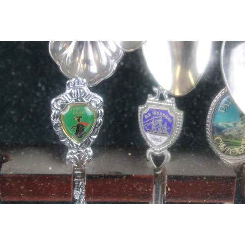 317 - A large collection of souvenir spoons contained within three collectors cabinets.