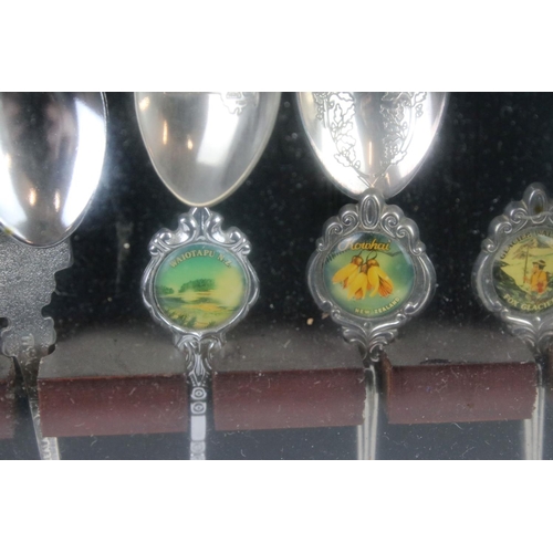 317 - A large collection of souvenir spoons contained within three collectors cabinets.