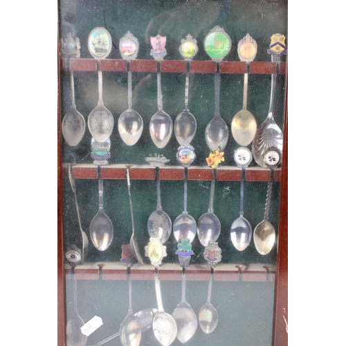 317 - A large collection of souvenir spoons contained within three collectors cabinets.