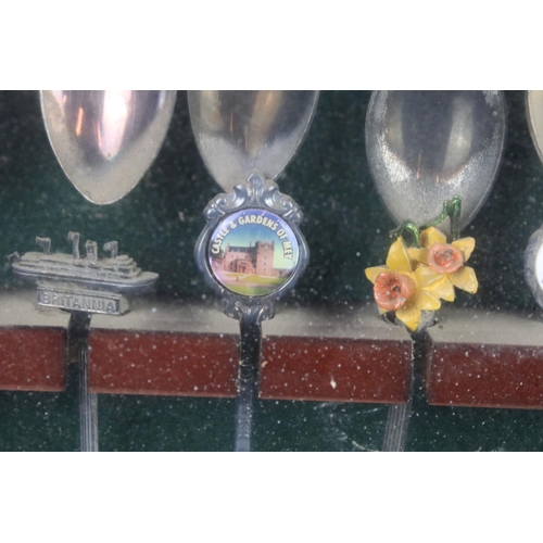 317 - A large collection of souvenir spoons contained within three collectors cabinets.