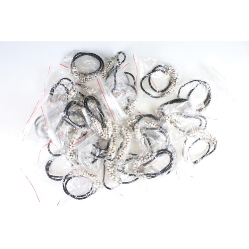 325 - A collection of twenty eight x lilac, white and grey pearls on leather.