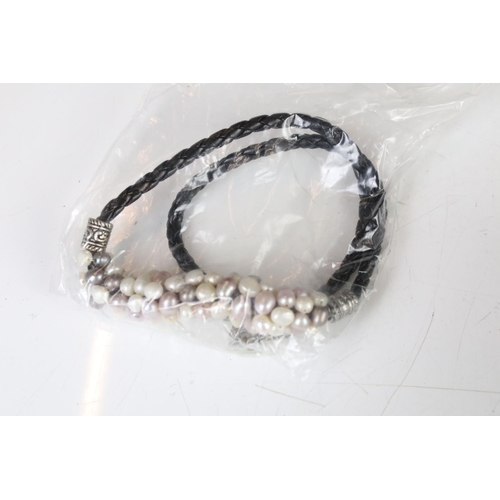 325 - A collection of twenty eight x lilac, white and grey pearls on leather.