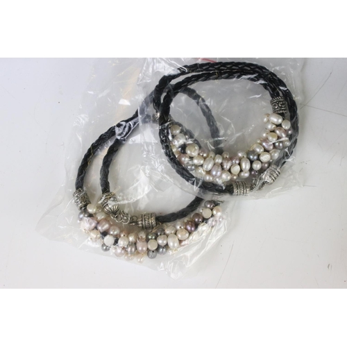 325 - A collection of twenty eight x lilac, white and grey pearls on leather.