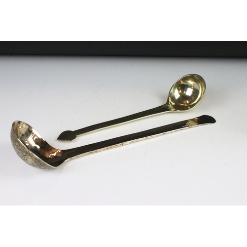 369 - A wrought iron and brass trivet together with a brass examples and two brass ladles.