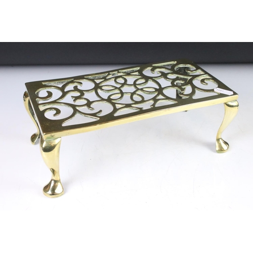 369 - A wrought iron and brass trivet together with a brass examples and two brass ladles.
