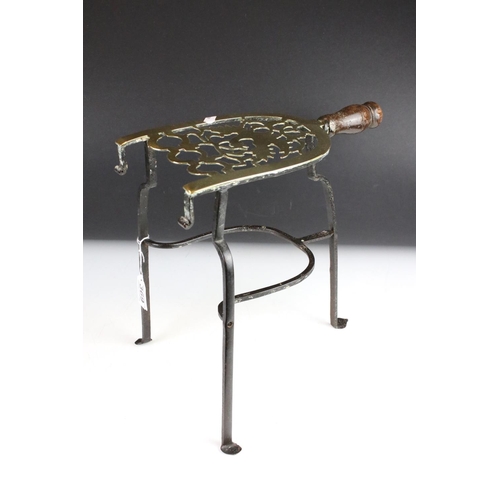 369 - A wrought iron and brass trivet together with a brass examples and two brass ladles.