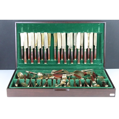 371 - A canteen of brass cutlery with polished wooden handles.