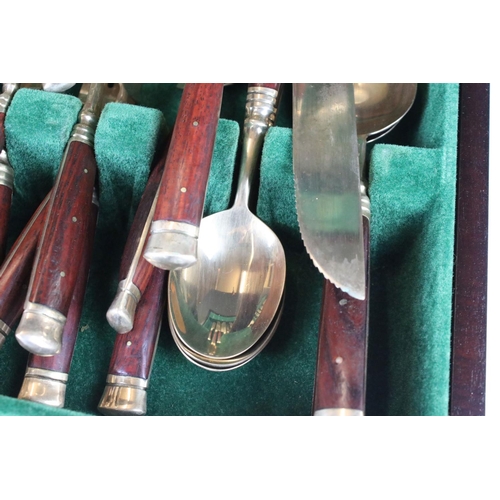 371 - A canteen of brass cutlery with polished wooden handles.