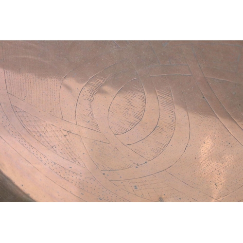 376 - A large copper charger with engraved decoration.