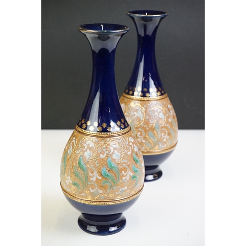 21 - Pair of early 20th century Royal Doulton stoneware vases, with hand decorated foliate design, on cob... 