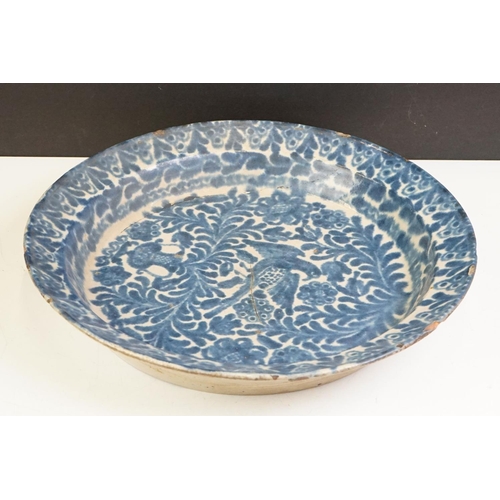 66 - 19th century blue & white pottery charger decorated with a bird amongst flora & fauna, 41cm diameter... 