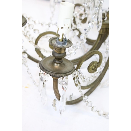 389 - An early 20th century brass six branch chandelier with glass droplet decoration.