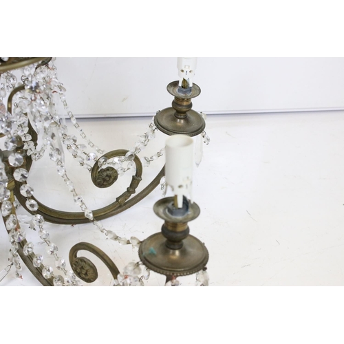 389 - An early 20th century brass six branch chandelier with glass droplet decoration.