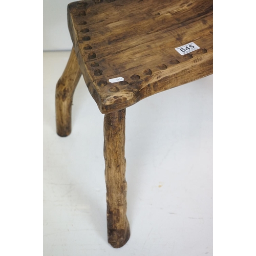 645 - Two Rustic Vernacular Stools, the smaller raised on three legs, largest stool measures 54cm long x 3... 