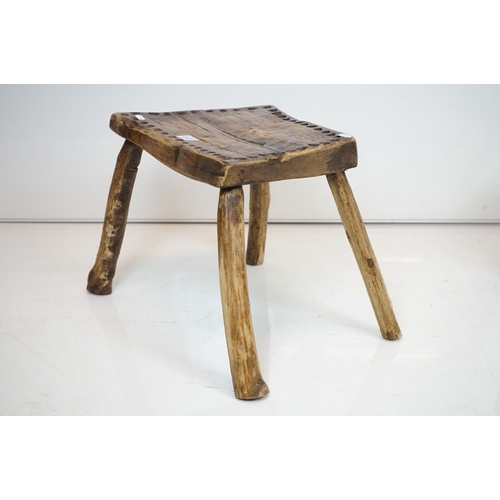 645 - Two Rustic Vernacular Stools, the smaller raised on three legs, largest stool measures 54cm long x 3... 