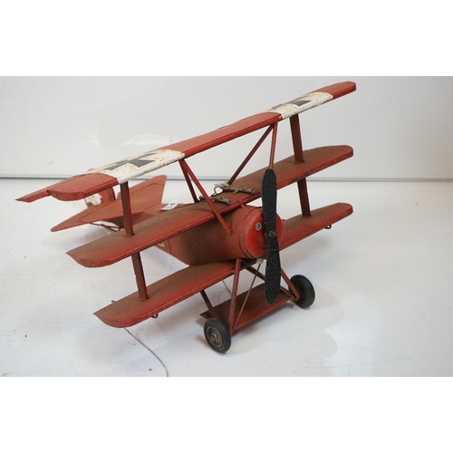 384 - A tinplate model of the Red Baron's Fokker trio plane, finish in red with iron cross insignia togeth... 