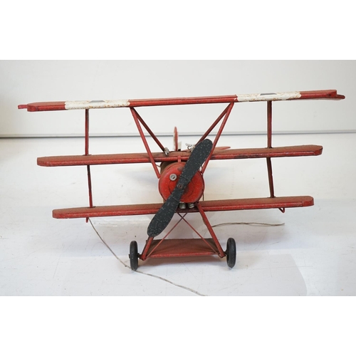 384 - A tinplate model of the Red Baron's Fokker trio plane, finish in red with iron cross insignia togeth... 