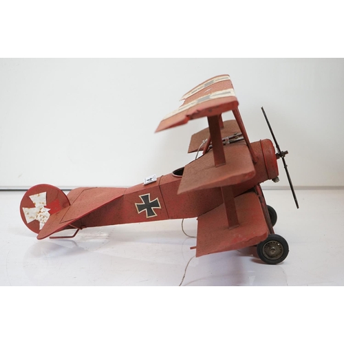 384 - A tinplate model of the Red Baron's Fokker trio plane, finish in red with iron cross insignia togeth... 