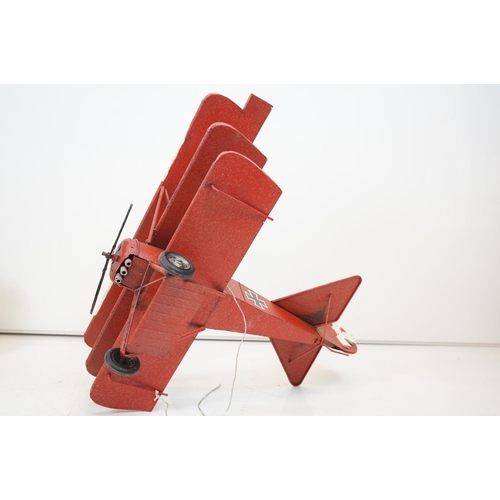 384 - A tinplate model of the Red Baron's Fokker trio plane, finish in red with iron cross insignia togeth... 
