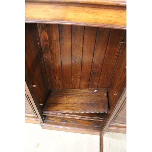 649 - Early 20th century Oak Breakfront Sideboard, the central glazed door opening to three adjustable she... 