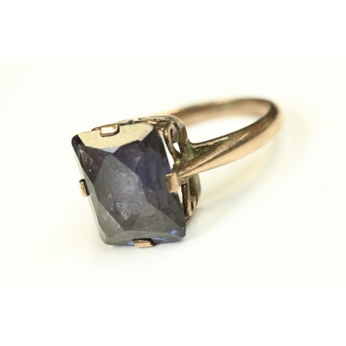 109 - Synthetic colour change sapphire rose metal ring, the rectangular mixed cut stone claw set, scroll m... 