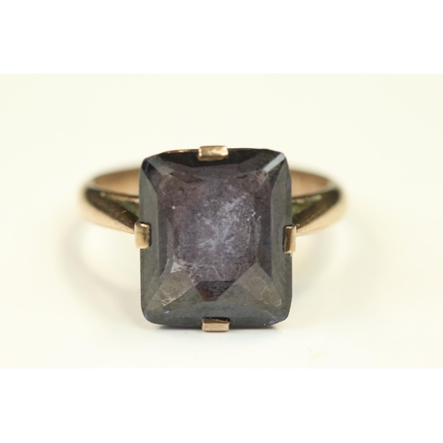 109 - Synthetic colour change sapphire rose metal ring, the rectangular mixed cut stone claw set, scroll m... 