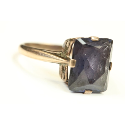 109 - Synthetic colour change sapphire rose metal ring, the rectangular mixed cut stone claw set, scroll m... 