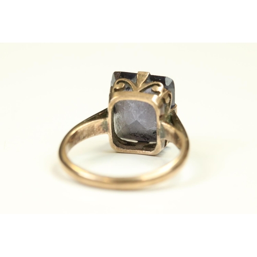 109 - Synthetic colour change sapphire rose metal ring, the rectangular mixed cut stone claw set, scroll m... 