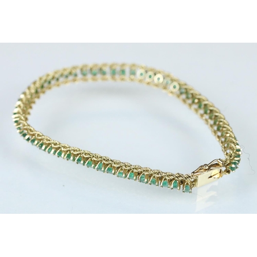92 - Emerald 14ct yellow gold line bracelet, fifty-four small round mixed cut emeralds, claw set, rope tw... 