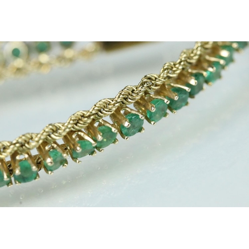 92 - Emerald 14ct yellow gold line bracelet, fifty-four small round mixed cut emeralds, claw set, rope tw... 