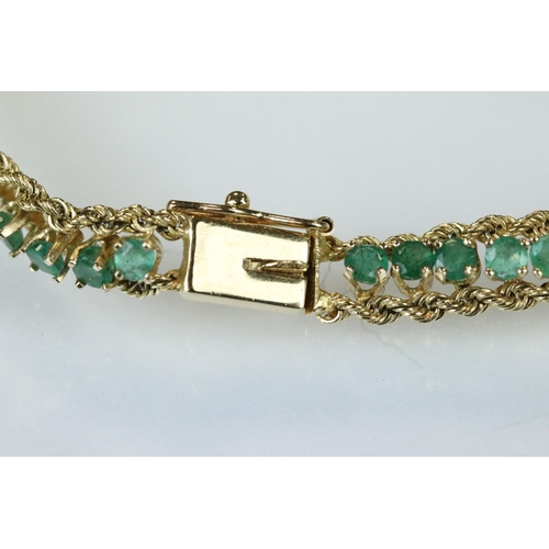 92 - Emerald 14ct yellow gold line bracelet, fifty-four small round mixed cut emeralds, claw set, rope tw... 