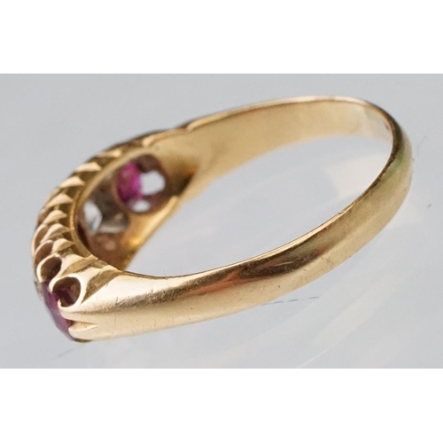 22 - Early 20th century ruby and diamond 18ct yellow gold ring, three graduated  round mixed cut rubies, ... 