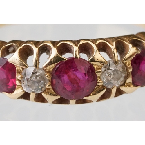 22 - Early 20th century ruby and diamond 18ct yellow gold ring, three graduated  round mixed cut rubies, ... 