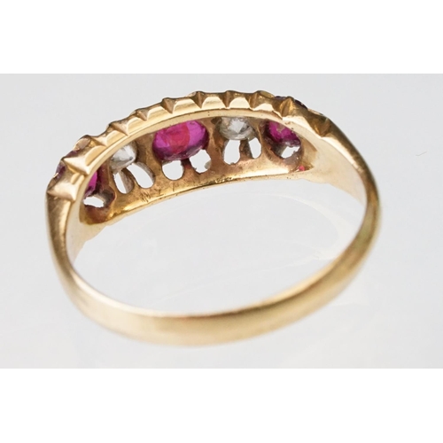 22 - Early 20th century ruby and diamond 18ct yellow gold ring, three graduated  round mixed cut rubies, ... 