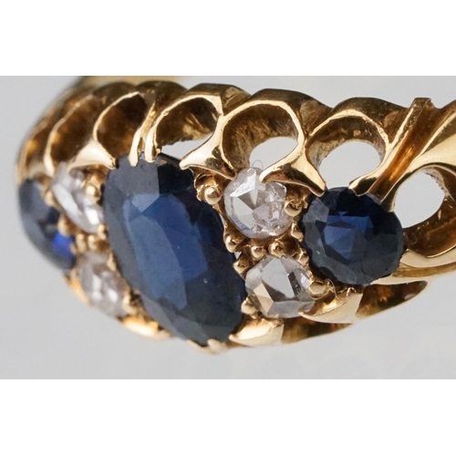 23 - Sapphire and diamond 18ct yellow gold boat head ring, the oval mixed cut principal sapphire measurin... 