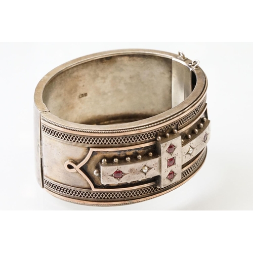 26 - Victorian paste and seed pearl parcel gilt silver hinged bangle, the raised central section set with... 