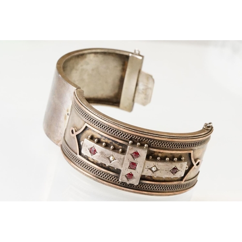 26 - Victorian paste and seed pearl parcel gilt silver hinged bangle, the raised central section set with... 