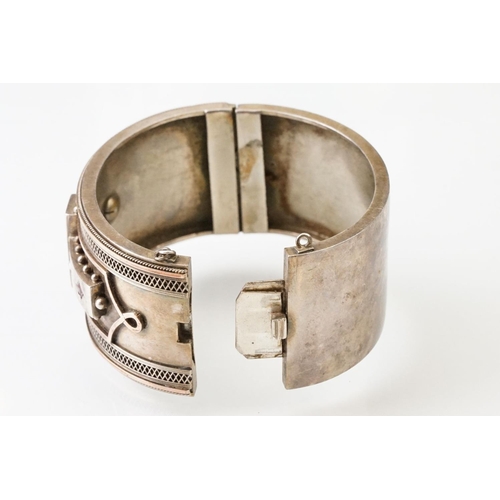 26 - Victorian paste and seed pearl parcel gilt silver hinged bangle, the raised central section set with... 
