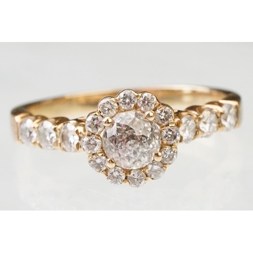 43 - Diamond halo yellow metal ring, the round mixed cut diamond measuring approx 5.6mm x 5.7mm x 4.7mm, ... 