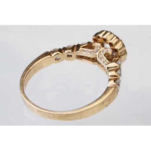 43 - Diamond halo yellow metal ring, the round mixed cut diamond measuring approx 5.6mm x 5.7mm x 4.7mm, ... 