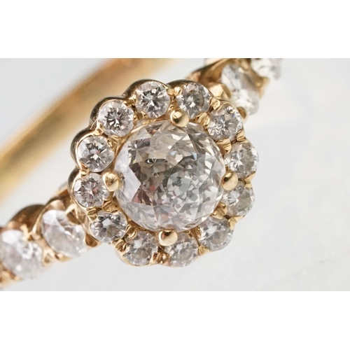 43 - Diamond halo yellow metal ring, the round mixed cut diamond measuring approx 5.6mm x 5.7mm x 4.7mm, ... 