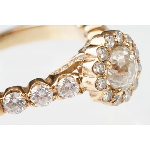 43 - Diamond halo yellow metal ring, the round mixed cut diamond measuring approx 5.6mm x 5.7mm x 4.7mm, ... 