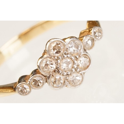 63 - Early 20th century diamond 18ct yellow gold and platinum set flower head ring, eleven small round ei... 
