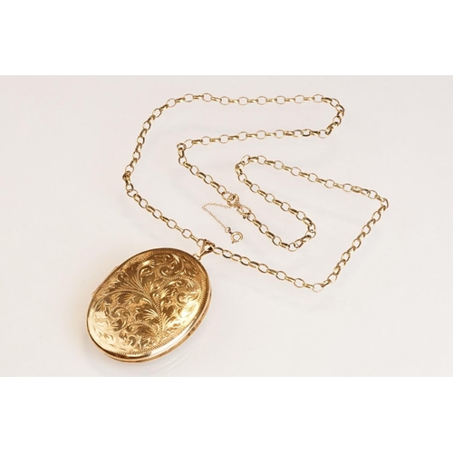 65 - Large yellow metal locket pendant necklace, the oval locket with engraved foliate decoration, dimens... 