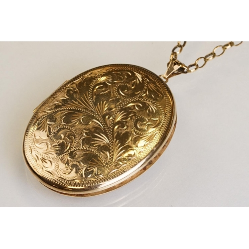 65 - Large yellow metal locket pendant necklace, the oval locket with engraved foliate decoration, dimens... 